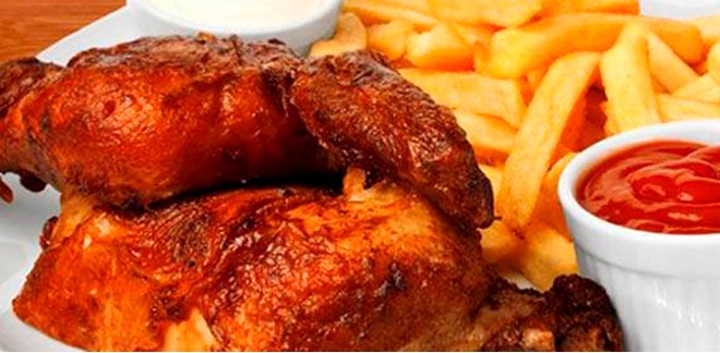 Peruvian chicken dish 'pollo a la brasa' served with chili sauce and fresh salad