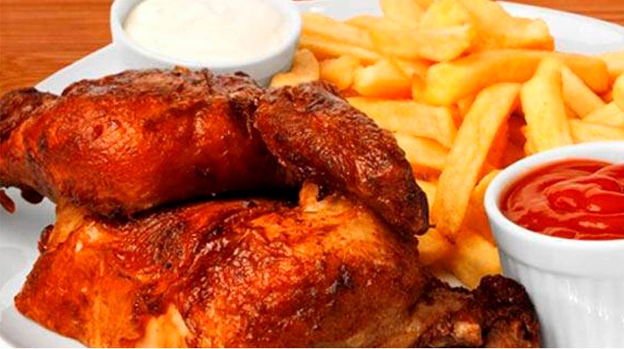Peruvian chicken dish 'pollo a la brasa' served with chili sauce and fresh salad